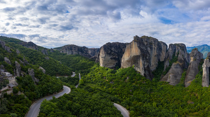 Aerial panorama view of a slide from a drone on a panorama of a mountain range. Kalampaka city, Greece. View of the cliffs of Meteora and the monasteries of Meteora.