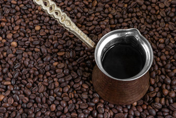 vintage cezve (turkish coffee) standing on coffee beans