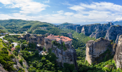 Fototapeta na wymiar Aerial panorama view of a slide from a drone on a panorama of a mountain range. Kalampaka city, Greece. View of the cliffs of Meteora and the monasteries of Meteora.