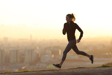 Fototapeta na wymiar Jogger jogging in city outskirts at sunset