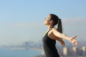 Relaxed runner breathing fresh air in city outskirts