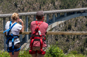 Bloukrans Bridge, Eastern Cape, South Africa. Dec 2019. Young couple wearing harnesses looking...