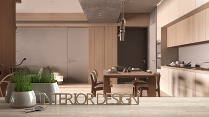 Wooden table, desk or shelf with potted grass plant, house keys and 3D letters making the words interior design, over minimal wooden kitchen, project concept copy space background