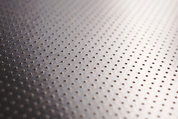 Aluminum metal surface with many notch spots. Abstract dark grey metallic background or wallpaper. Rows of points go into the distance and form a perspective. Macro