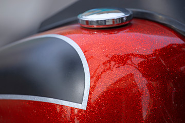 Réservoir customisé rouge métallisé de moto grosse cylindrée.