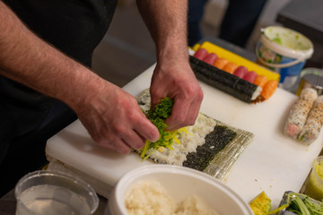 hands making sushi