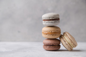 Macarons chocolate, caramel and vanilla on light background