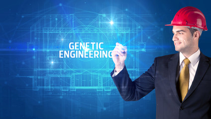 Handsome architect with helmet drawing GENETIC ENGINEERING inscription, new technology concept