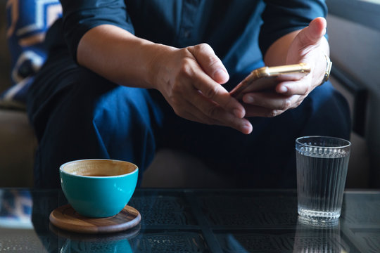 Businessman Using Smartphone To Read Investment News And Reply Email To Confirm Meeting In Coffee Shop. Man Drinking Latte Coffee Before Going To Work On Monday Morning. Vintage Photo And Film Style