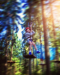 Fototapeta na wymiar young girl rides down a zipline