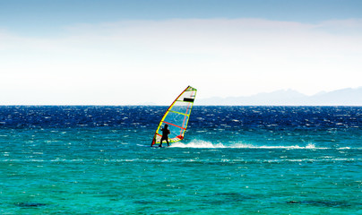 windsurfer on the background of mountains rides on the waves of the Red Sea in Egypt Dahab South Sinai