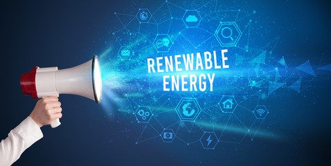 Young woman shouting in megaphone with RENEWABLE ENERGY inscription, Modern technology announcement...