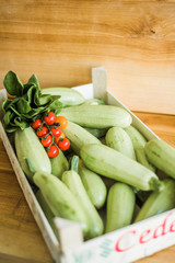 Organic zucchini and tomato in box. Fresh farm products.