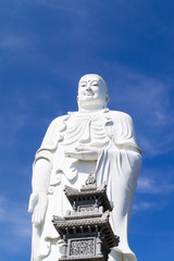 statue of a large white buddha against a blue sky