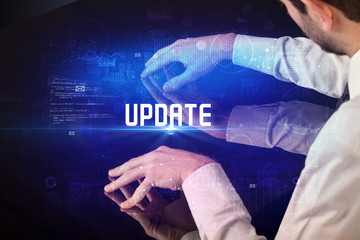 Hand touching digital table with UPDATE inscription, new age security concept