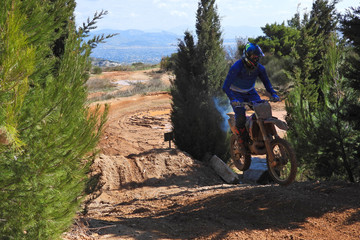 Zoom photo of mud track enduro motocross rider performing freestyle stunts in high speed