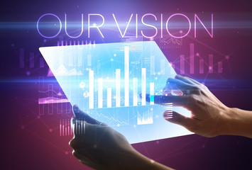 Hand holding futuristic tablet with OUR VISION inscription above, modern business concept