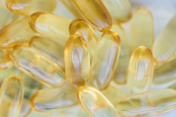 Pile capsules omega 3 in glass bottle on wooden table background. Vitamin D-3 capsules in bottle....