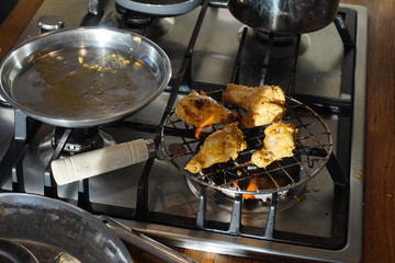 Chicken meat on a home gas grill on a Sunny day. Chicken with a toasted crust in the process of cooking. Pieces of poultry are fried on grille