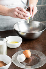 The recipe for making muffins. Ingredients for making muffins. A woman is cooking pastries. The cook breaks the egg with a knife.