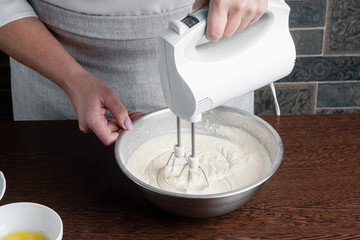 The recipe for making muffins. Ingredients for making muffins. A woman is cooking pastries. The cook kneads the dough.