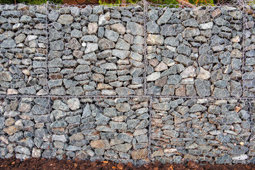 Mesh and stone fence, gabion for use in civil engineering, road building, military applications and landscaping.