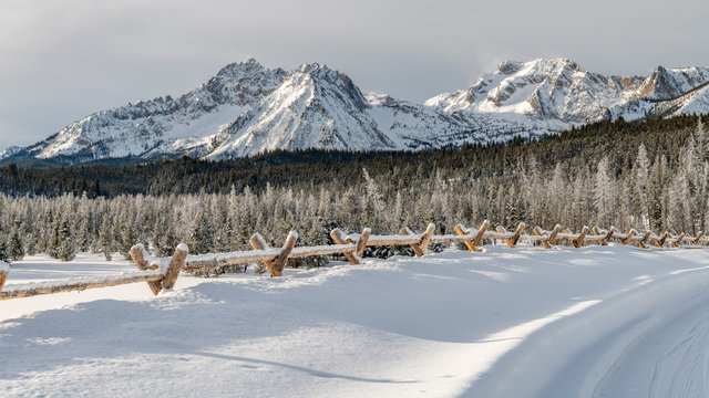 Pole Fence Sticks Above The Snow Along And Idaho Road With A Mountain Rage