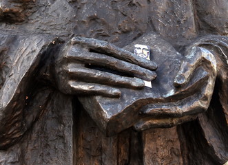 Hände mit Heiligenbild am Denkmal des Warschauer Aufstandes