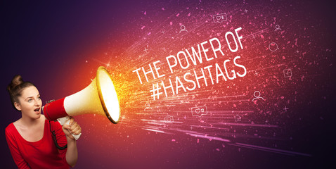 Young woman yelling to loudspeaker with THE POWER OF #HASHTAGS inscription, social networking...