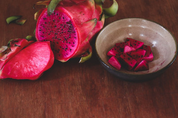Sliced red dragonfruit against a wooden background showing concept of summer, healthy food,...