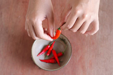 Close up of hands preparing red chilies for cooking to show concept of gastronomy, cuisine, clean...