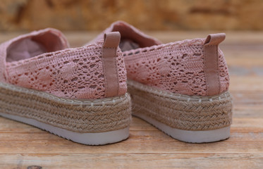 Espadrilles with rubber sole on wood background, close-up