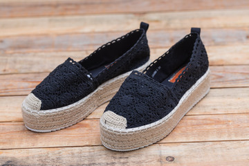 Espadrilles with rubber sole on wood background, close-up