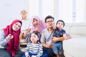 Big muslim family watching television joyfully