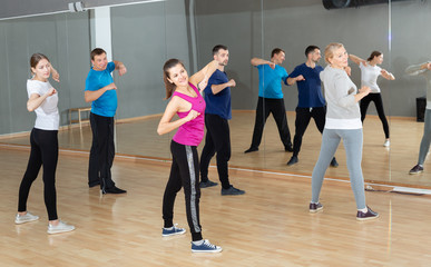 Fototapeta na wymiar Females and males stretching at dance class