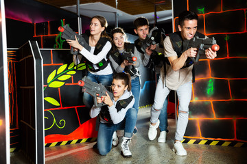Obraz na płótnie Canvas Group glad people playing laser tag game