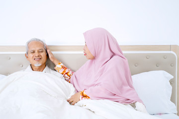 Elderly muslim woman caressing her pale husband