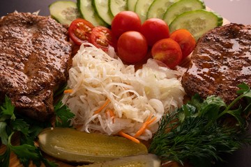 Fried meat with cabbages and salad close up view