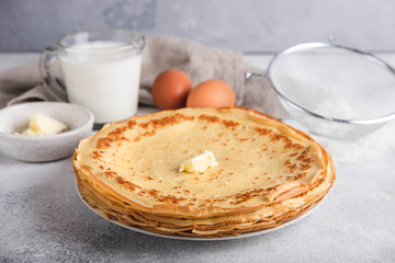 Maslenitsa week festival. A stack of russian pancakes with butter. Ingredients for cooking russian pancakes. Rustic style, close-up horisontal.