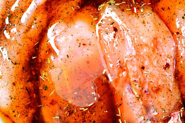 Raw turkey meat in marinade with spice, oil, thyme, rosemary and pepper - obrazy, fototapety, plakaty