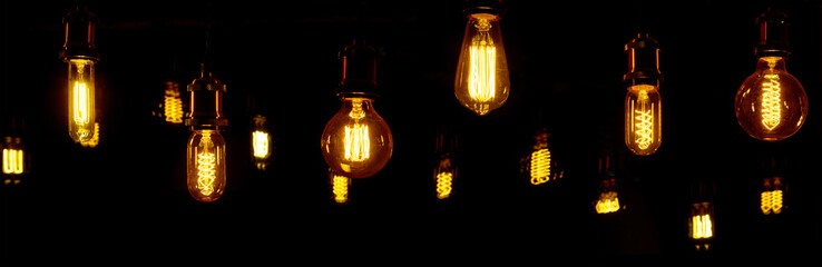 Mehrere nicht besonders hell leuchtende Lampen vor dunklem Hintergrund.