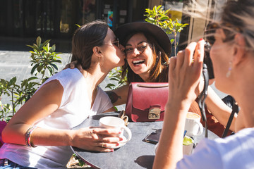 Three Women Friends Having Fun in a Cafe Terrace.