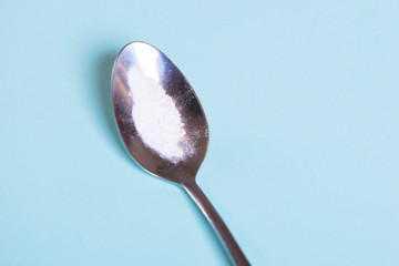 spoon with white powder on a blue background