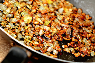Detail of golden chopped onion fried in oil in pan.