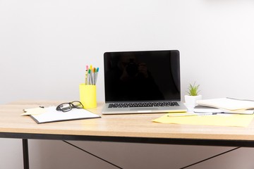 Front view of creative designer desktop with laptop ,notebook , supplies.