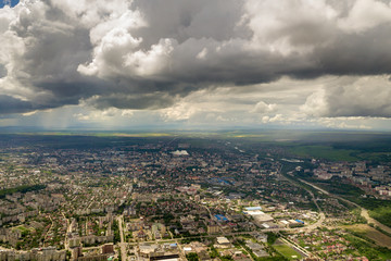 Aerial view of town or city with rows of buildings and curvy streets in summer. Urban landscape from above.