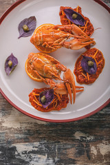 Vertical shot boiled crayfish on a plate. Delicacy with chili pepper sauce, basil and capers. Gourmet cuisine. Top view. Copy space