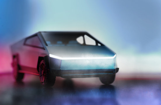 Tesla brand cybertruck pickup car on a dark background with lights.