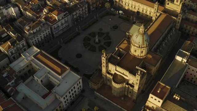 Cinematic flight early sunny morning over the Cattadrale Santa Vergine Maria Assunta, Palazzo dei Normanni, and Cappella Palatina, in the historic part of Palermo. Sicily, Italy. May 2019. Aerial shot