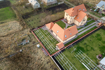 Top down aerial view of a private house with red tiled roof and frame structure prepared for...